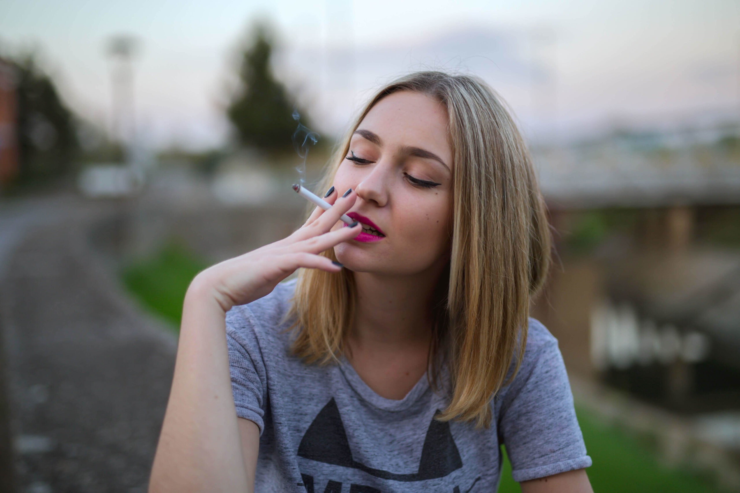 A sweet girl smoking outdoor.
