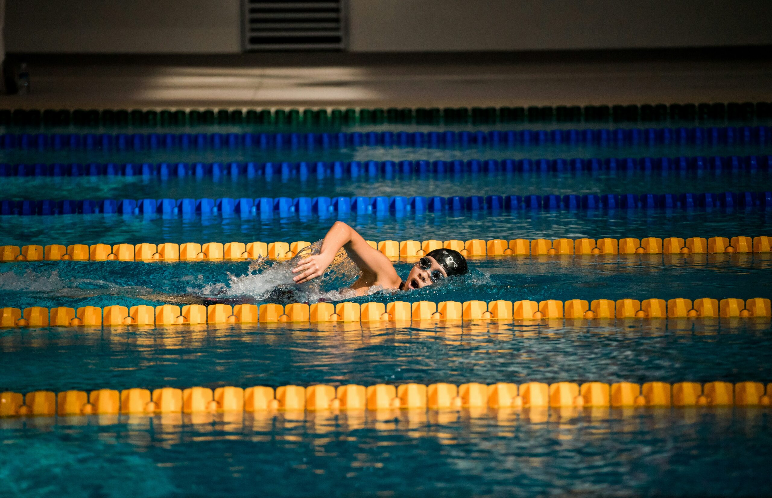 A children wearing goggles and swimming in water.
